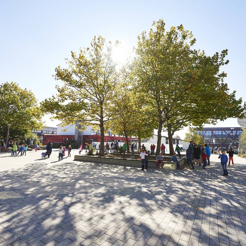 Pausenhof bei Sonnenschein mit spielenden Kindern